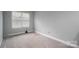 Clean, carpeted bedroom with a window providing natural light at 2388 Loch Stone Dr # E, Gastonia, NC 28054