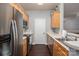 Galley kitchen features stainless steel appliances, light wood cabinets and ample counter space at 2388 Loch Stone Dr # E, Gastonia, NC 28054