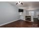 Open living room with fireplace, ceiling fan, and dark wood floors at 2388 Loch Stone Dr # E, Gastonia, NC 28054