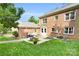 Spacious backyard with lush green grass, brick exterior, and a patio area for outdoor dining at 2417 Hamilton Mill Rd, Charlotte, NC 28270
