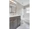 This bathroom features a dark vanity with bright white tiles and bright natural light at 2417 Hamilton Mill Rd, Charlotte, NC 28270