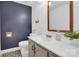 A bathroom features a dark blue accent wall, white vanity, and decorative touches at 2417 Hamilton Mill Rd, Charlotte, NC 28270