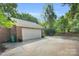 Detached brick garage with a wide driveway and mature landscaping at 2417 Hamilton Mill Rd, Charlotte, NC 28270