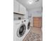 Bright laundry room featuring a washer, dryer, storage cabinet, and tile flooring at 2417 Hamilton Mill Rd, Charlotte, NC 28270