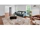 Bright living room featuring a blue velvet sofa, ottoman, and large windows with natural light at 2417 Hamilton Mill Rd, Charlotte, NC 28270