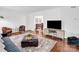 Open-concept living room with hardwood floors, comfortable seating, and a view into the dining area at 2417 Hamilton Mill Rd, Charlotte, NC 28270