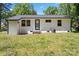 White brick exterior with a black door and windows, plus a grassy backyard and green trees at 2515 Danforth Ln, Charlotte, NC 28208