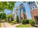 Low angle of modern townhomes with professionally landscaped yards, a sidewalk, and a blue sky at 2551 Statesville Ave, Charlotte, NC 28206