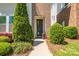 Close up of the townhome entrance, featuring a modern front door and professionally landscaped yard at 2551 Statesville Ave, Charlotte, NC 28206