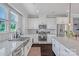 Well-lit kitchen with granite countertops, stainless steel appliances, and a large farmhouse sink under the window at 2551 Statesville Ave, Charlotte, NC 28206