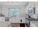 Modern kitchen with granite countertops, a stainless steel sink, and appliances set against white cabinetry at 2551 Statesville Ave, Charlotte, NC 28206