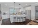 Well-lit kitchen featuring an island with barstool seating, granite countertops and stainless steel appliances at 2551 Statesville Ave, Charlotte, NC 28206