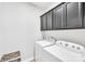 Well-lit laundry area with modern washer and dryer units, plus sleek overhead cabinetry at 2551 Statesville Ave, Charlotte, NC 28206
