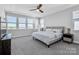 Comfortable bedroom with a ceiling fan, three large windows, and neutral decor at 2551 Statesville Ave, Charlotte, NC 28206