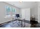 Bright office space features a modern desk, sleek Murphy bed, and sun-filled windows at 2551 Statesville Ave, Charlotte, NC 28206