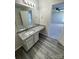 Granite countertop and white cabinets in a modern bathroom with gray wood-look floors at 2815 Cartesian Dr, Charlotte, NC 28214