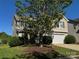 Charming home exterior features a two-car garage, lush green lawn, and a mature shade tree at 2815 Cartesian Dr, Charlotte, NC 28214