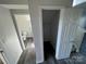Hallway showing access to a half bath and a storage closet with modern flooring at 2815 Cartesian Dr, Charlotte, NC 28214