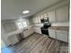 Well-lit kitchen featuring stainless steel appliances, gray cabinets, granite countertops, and wood-look flooring at 2815 Cartesian Dr, Charlotte, NC 28214