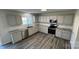 Well-lit kitchen featuring stainless steel appliances, gray cabinets, granite countertops, and wood-look flooring at 2815 Cartesian Dr, Charlotte, NC 28214