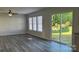 Bright living room with wood-look flooring, three windows, and a sliding door to the backyard at 2815 Cartesian Dr, Charlotte, NC 28214