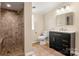 Bathroom with tiled shower, black vanity with white countertop, and earth-tone tile flooring at 2942 Denwood Dr, Claremont, NC 28610