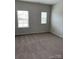 Well-lit bedroom with neutral carpeting and two windows providing natural light, creating a serene space at 3019 Glenn Hope Way, Matthews, NC 28104