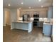 Modern kitchen with stainless steel appliances, granite countertops, and grey cabinetry at 3019 Glenn Hope Way, Matthews, NC 28104