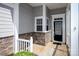Covered front porch showcasing stone accents, white pillars, and a black front door at 3040 Azalea Dr, Indian Land, SC 29707
