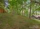This backyard retreat has a grassy area with mature trees and a glimpse of the home's unique architecture at 3232 Johnny Cake Ln, Charlotte, NC 28226