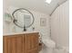 Modern bathroom with wood vanity, quartz countertop, and oval mirror at 3232 Johnny Cake Ln, Charlotte, NC 28226
