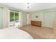 Bedroom featuring light green walls, light hardwood flooring, and sliding door leading to the patio at 3232 Johnny Cake Ln, Charlotte, NC 28226