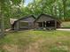 Contemporary home featuring a covered outdoor space, dark siding, and lush landscaping at 3232 Johnny Cake Ln, Charlotte, NC 28226