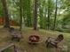 This backyard features a cozy fire pit with Adirondack chairs, surrounded by lush greenery at 3232 Johnny Cake Ln, Charlotte, NC 28226