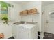 Well-lit laundry room with washer, dryer, storage shelves, and window at 3232 Johnny Cake Ln, Charlotte, NC 28226