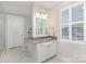 Well-lit bathroom with white cabinetry, gray countertop, and window with plantation shutters at 4237 Island Fox Ln, Denver, NC 28037