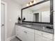 Bathroom with granite countertops, white cabinets, and a large framed mirror at 4237 Island Fox Ln, Denver, NC 28037