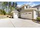 Spacious three-car garage with white doors and concrete driveway surrounded by lush trees and greenery at 4237 Island Fox Ln, Denver, NC 28037