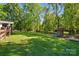 Expansive backyard featuring lush greenery, a wooden fence, and a playground with a playset at 4307 Wrangler Sw Dr, Concord, NC 28027