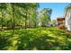 Expansive backyard showcasing a lush green lawn, mature trees, and room to relax or play at 4307 Wrangler Sw Dr, Concord, NC 28027