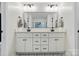Modern bathroom vanity featuring double sinks, sleek fixtures, and a large mirror at 4307 Wrangler Sw Dr, Concord, NC 28027