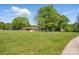 Expansive front yard with mature trees and a view of the charming single-story home at 4307 Wrangler Sw Dr, Concord, NC 28027