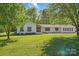 Charming single-story home with mature trees and a lush, green front lawn at 4307 Wrangler Sw Dr, Concord, NC 28027