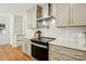 Close-up of the stove and modern cabinets in a bright kitchen with stainless steel vent at 4307 Wrangler Sw Dr, Concord, NC 28027