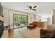 Cozy living room with natural light, hardwood floors, ceiling fan, and open access to the kitchen at 4307 Wrangler Sw Dr, Concord, NC 28027