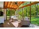 Relaxing screened porch with wood ceiling features comfortable seating overlooking the serene backyard at 4307 Wrangler Sw Dr, Concord, NC 28027