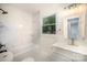 Bright bathroom features modern fixtures, shower over tub with tiled surround, and a window at 4921 Churchill Dr, Charlotte, NC 28269