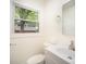 Neutral bathroom features a white vanity, toilet, modern fixtures, and view to the backyard at 4921 Churchill Dr, Charlotte, NC 28269