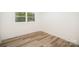 Bright bedroom features wood-look flooring and a large window with view to the backyard at 4921 Churchill Dr, Charlotte, NC 28269