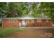 Charming brick home featuring a well-maintained yard, bright windows, and inviting front entrance at 4921 Churchill Dr, Charlotte, NC 28269